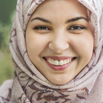 Smiling woman wearing a headscarf.