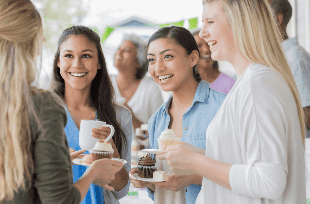 Group of women socializing and eating cupcakes